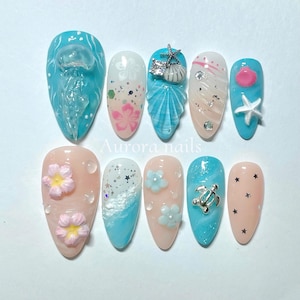 Press-on nail set featuring jellyfish, sea turtles, and delicate floral accents. Perfect for beach days and tropical vibes!