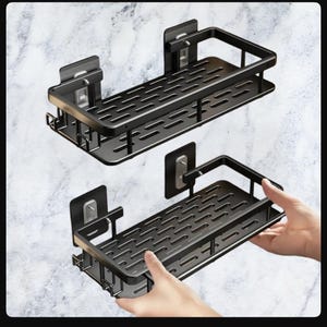 Puede incluir: Dos estantes de ducha de metal negro con un diseño rectangular y un borde elevado. Los estantes se muestran con respaldo adhesivo para una fácil instalación. El fondo es una pared con diseño de mármol.