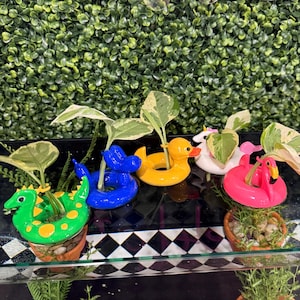 May include: A set of three ceramic mugs with a speckled, matte finish. The mugs are in shades of cream, light gray, and dark gray. Each mug has a simple, minimalist design, perfect for coffee or tea.