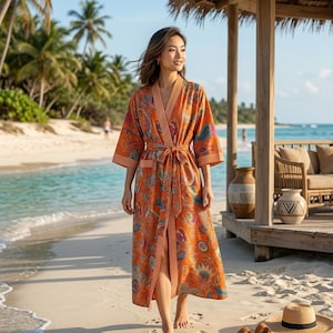 Può includere: Una vestaglia lunga color arancione con un vivace motivo floreale e paisley multicolore. Il capo presenta maniche ampie, una cintura da annodare in vita e bordi a righe verticali lungo l'apertura frontale e sui polsini delle maniche.