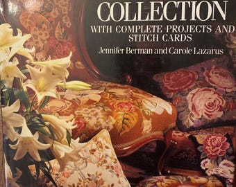 May include: The cover of "The Floralilia Needlepoint Collection" book. The book cover is dark with the title in pink and white. The image shows a floral design with pillows and a chair with a floral pattern. White lilies are in the foreground.