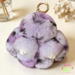 May include: A white ceramic mug with a black handle and the text "But First, Coffee" in a bold, black font. The mug is set against a blurred background, highlighting its simple design.