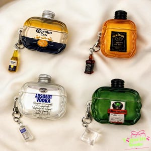 Pode incluir: Quatro capas para AirPods em forma de garrafas de licor: Corona Extra, Jack Daniel's, Absolut Vodka e Jägermeister. Cada capa tem um pingente de garrafa em miniatura ou cubo de gelo correspondente. As capas são transparentes com detalhes coloridos e de garrafa.