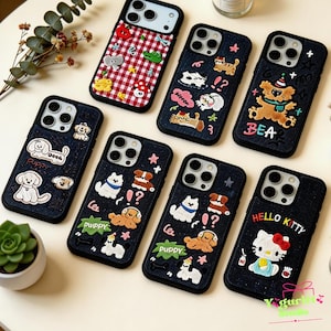 May include: A collection of phone cases with various embroidered designs. The cases are primarily dark blue and feature images of puppies, cats, and other cute characters. One case has a red and white checkered pattern, and another says "HELLO KITTY".