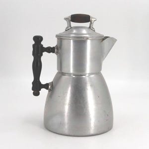 May include: A set of three ceramic mugs with a speckled, cream-colored glaze. Each mug features a different hand-painted floral design in shades of blue, green, and yellow. The mugs have a simple, rounded shape and a comfortable handle.