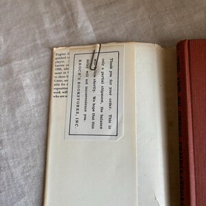 May include: An open book with a red cover and a white paper insert held in place by a paper clip. The insert has text that reads "Thank you for your order..." and "KROCH'S BOOKSTORES, INC."