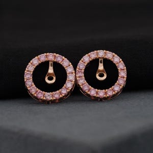 Può includere: Un paio di giacche per orecchini in oro rosa. Ogni giacca è un cerchio con un anello di piccole pietre preziose rosa. Gli orecchini hanno un perno e un piccolo anello per il fissaggio a un orecchino.