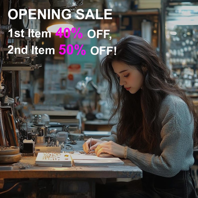 May include: A woman working at a workbench, possibly crafting jewelry. The image features the text "OPENING SALE" with discounts of 40% and 50% off. The woman is wearing a gray sweater and is focused on her work.