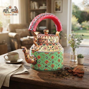 May include: A hand-painted metal tea kettle featuring a vibrant green base with orange floral patterns, a gold-toned midsection with intricate leaf motifs, and a bright red arched handle. The spout and lid are decorated with matching floral designs.