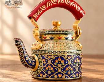 May include: A decorative metal teapot featuring a vibrant red handle with gold patterns, a gold lid, and a blue body adorned with intricate floral motifs, geometric designs, and small embedded crystals. The spout is striped in red, green, and blue.