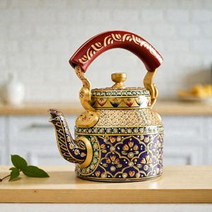 May include: Ornate, hand-painted teapot with a red handle and gold accents. The teapot features a detailed floral pattern in shades of blue, gold, and green. The spout and handle are intricately designed, showcasing a blend of traditional craftsmanship and decorative artistry.