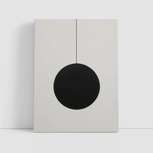 May include: A rectangular wall art print featuring a solid black circle centered in the lower half of a light gray background. A single thin black vertical line extends from the top edge of the print down to the top center of the black circle.