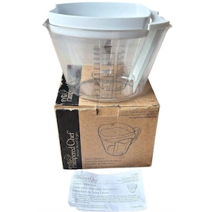 Puede incluir: Un separador de grasa para salsas de plástico transparente con tapa y asa blancas, que presenta marcas de medición negras en mililitros y tazas hasta 1000 ml. Se muestra con su caja de cartón original y un manual de instrucciones blanco.
