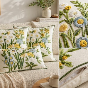 以下が含まれることがあります： 刺繍された花の模様が施された、3つの装飾用スロー枕のセット。枕は、黄、青、白の花と緑の茎と葉の精巧な刺繍が施された白い生地が特徴です。各枕には緑色の縁取りが施されています。
