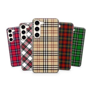 Puede incluir: Una colección de fundas para teléfonos con patrones de cuadros en rojo, blanco, negro, beige y verde. Las fundas están diseñadas para un teléfono inteligente y tienen recortes para la cámara.