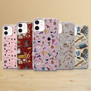 Puede incluir: Cinco fundas para teléfono con varios diseños. Las fundas presentan diseños con símbolos, objetos y personajes de una serie de fantasía. Las fundas son en tonos rosa, rojo, morado, gris y beige, con una superficie de madera en primer plano.