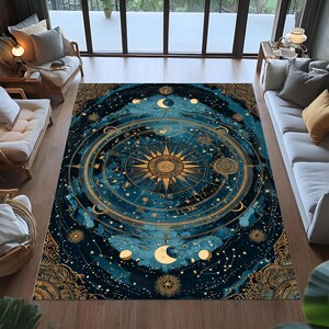 May include: A large, rectangular rug with a celestial design. The rug has a dark blue background with gold accents depicting constellations, moons, and a central sunburst. The rug is placed on a wooden floor in a living room setting.