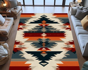 May include: A large area rug with a geometric pattern in shades of cream, orange, navy, and gray. The rug features a central design of layered triangles and diamond shapes, creating a Southwestern or tribal aesthetic. The rug is placed on a hardwood floor.