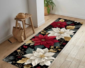 Op de afbeelding: Een rechthoekig zwart tapijt met grote rode en witte poinsettia bloemen met gouden en groene accenten. Het bloemmotief is geplaatst tegen een zwarte achtergrond met decoratieve krullen en hulstbessen. Een feestelijk woondecoratie-artikel.