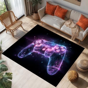 May include: Black rectangular rug with a neon-style video game controller design in purple and blue hues. The rug is placed on a wooden floor, with a sofa and chair in the background. The controller design has a futuristic look.