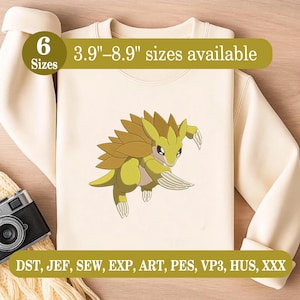 May include: A cream-coloured sweatshirt with an embroidered cartoon creature in yellow and brown. The design includes the text "6 Sizes" and "3.9"-8.9" sizes available". The bottom of the sweatshirt has the text "DST, JEF, SEW, EXP, ART, PES, VP3, HUS, XXX".