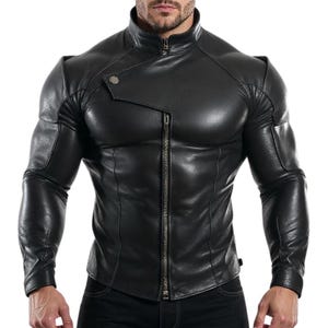 Könnte beinhalten: Schwarze Lederjacke mit Stehkragen und asymmetrischem Reißverschluss. Die Jacke hat lange Ärmel und eine taillierte Passform. Das Design umfasst ein kleines, abgewinkeltes Druckknopfdetail auf der oberen Brust.