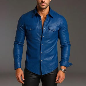 Può includere: Una camicia in pelle blu cobalto a maniche lunghe con due tasche sul petto e bottoni color argento. La camicia ha un colletto classico e polsini con bottoni. La persona indossa un orologio d'argento.