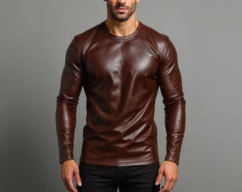 May include: A long-sleeved, brown leather shirt with a crew neck. The shirt has a shiny, textured appearance and is worn with black pants. The image is set against a gray background.