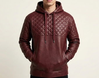 May include: A burgundy leather hoodie with a quilted pattern on the upper chest and hood. The hoodie has a drawstring and a kangaroo pocket. The sleeves and lower body are a solid burgundy color.