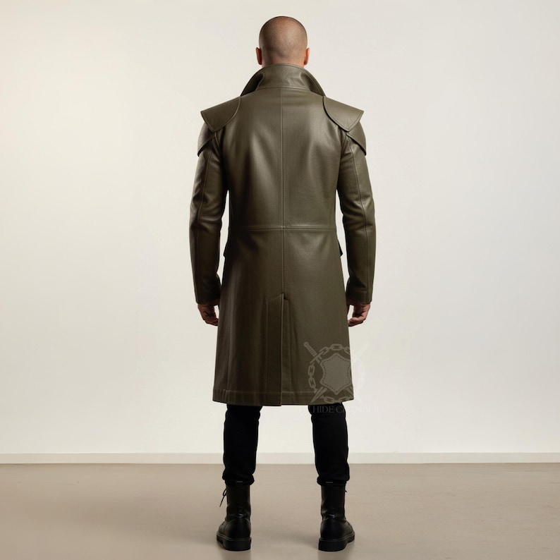 May include: Olive green leather coat with shoulder accents and a long, tailored fit. The coat features a notched collar, long sleeves, and a button-down front. The model is wearing black pants and boots. The coat is approximately 55 inches long.