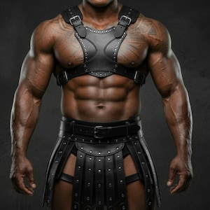 Könnte beinhalten: Schwarzes Leder-Brustgeschirr und -Rock mit silberfarbenen Nieten und Schnallen. Das Geschirr hat ein zentrales Design mit dekorativen Nähten. Der Rock hat ein geschichtetes Design mit einem Gürtel. Das Outfit ist für einen kühnen, kantigen Look konzipiert.