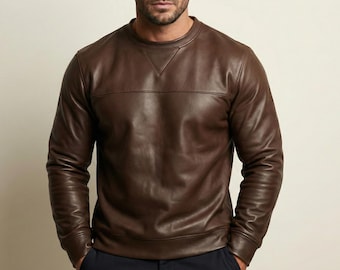 May include: A brown leather sweatshirt with a crew neck and long sleeves. The leather has a smooth texture and a horizontal seam across the chest. The sweatshirt is a rich, dark brown color.