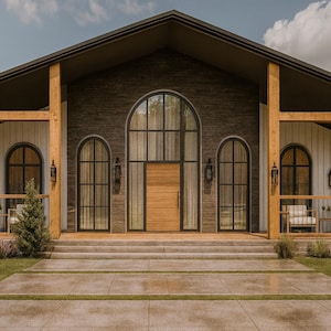 May include: Exterior view of a modern building with a dark gray roof and facade. The building features large arched windows and a wooden door. Porches with seating flank the entrance, and the building is surrounded by green grass and trees.
