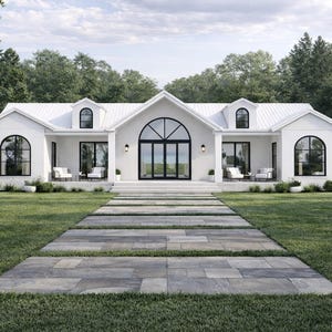 May include: A white, modern farmhouse with a symmetrical design. The house features a white roof, black-framed windows, and a large arched glass door. A stone pathway leads to the entrance, surrounded by green grass and trees.