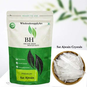 Op de afbeelding: Een verpakking van "Sat Ajwain" biologische zaden met een groen en wit ontwerp, en een houten kom gevuld met heldere kristallen. De verpakking heeft de tekst "WholesalesupplyArt", "BH Organic Seeds High Quality" en "Premium Sat Ajwain".