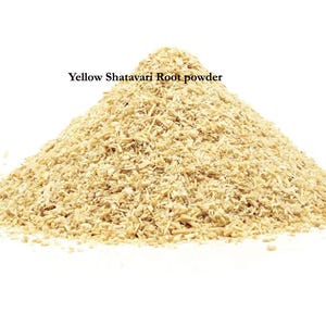 K&ouml;nnte beinhalten: Ein Haufen gelbes Shatavari-Wurzelpulver vor wei&szlig;em Hintergrund. Das Pulver hat eine hellbraune Farbe und scheint fein gemahlen zu sein. Der Text "Yellow Shatavari Root powder" wird &uuml;ber dem Pulver angezeigt.