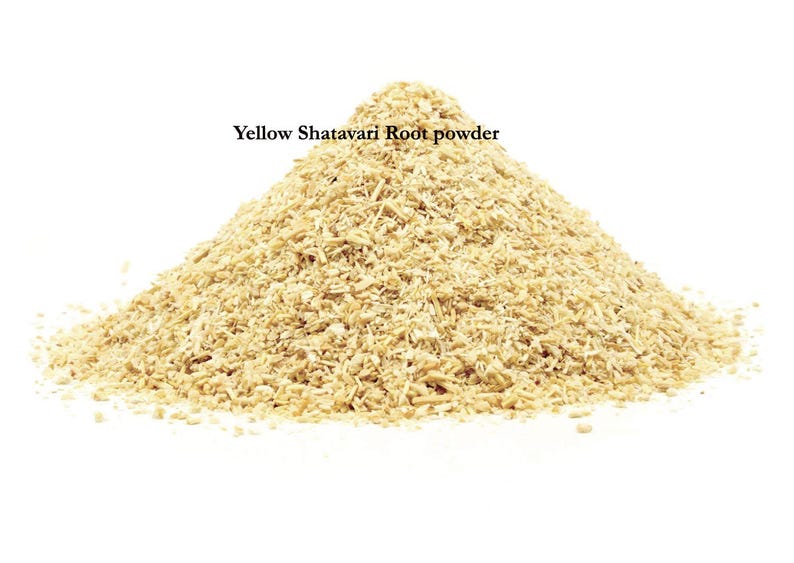 K&ouml;nnte beinhalten: Ein Haufen gelbes Shatavari-Wurzelpulver vor wei&szlig;em Hintergrund. Das Pulver hat eine hellbraune Farbe und scheint fein gemahlen zu sein. Der Text "Yellow Shatavari Root powder" wird &uuml;ber dem Pulver angezeigt.