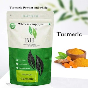 Pode incluir: Um pacote de açafrão em pó premium e raiz de açafrão inteira. O pacote é branco e verde com o texto "Turmeric Powder and whole" e "Premium Turmeric". Uma pequena tigela de madeira contém açafrão em pó.
