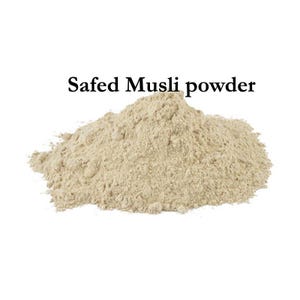 May include: A pile of light beige Safed Musli powder against a white background. The text "Safed Musli powder" is displayed in black, centered above the powder.