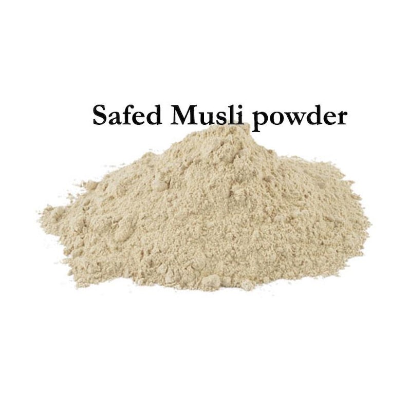 May include: A pile of light beige Safed Musli powder against a white background. The text "Safed Musli powder" is displayed in black, centered above the powder.