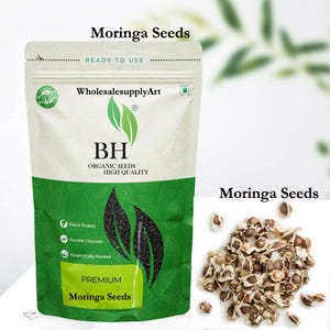 May include: A packet of premium Moringa seeds, labelled "Moringa Seeds" and "BH Organic Seeds High Quality". The packet is white and green with a natural product seal. A pile of Moringa seeds is next to the packet.