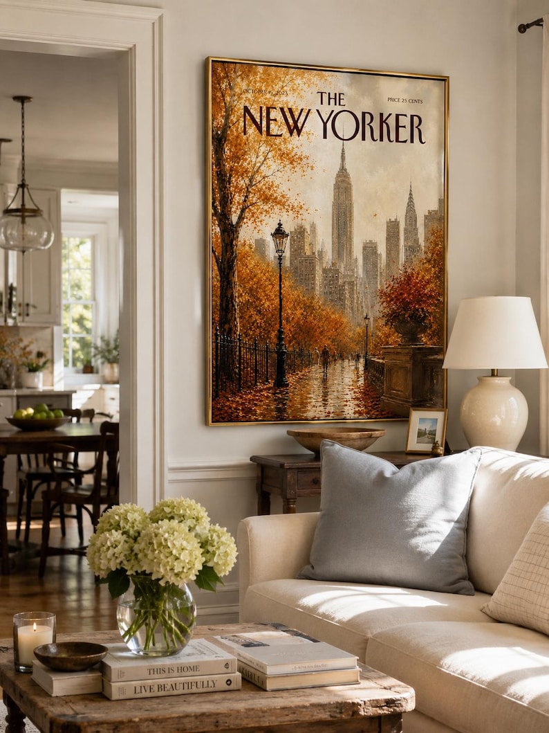 May include: A framed wall art print of a New Yorker magazine cover featuring an autumn scene in New York City with the Empire State Building, golden trees, a street lamp, and a wet path, all rendered in warm orange and brown tones.