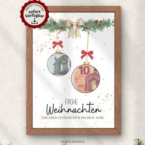 May include: A framed Christmas-themed print featuring two ornaments with currency designs, suspended from a garland with a bow. The print includes the text "Frohe Weihnachten" and "Und einen guten Rutsch ins neue Jahr."