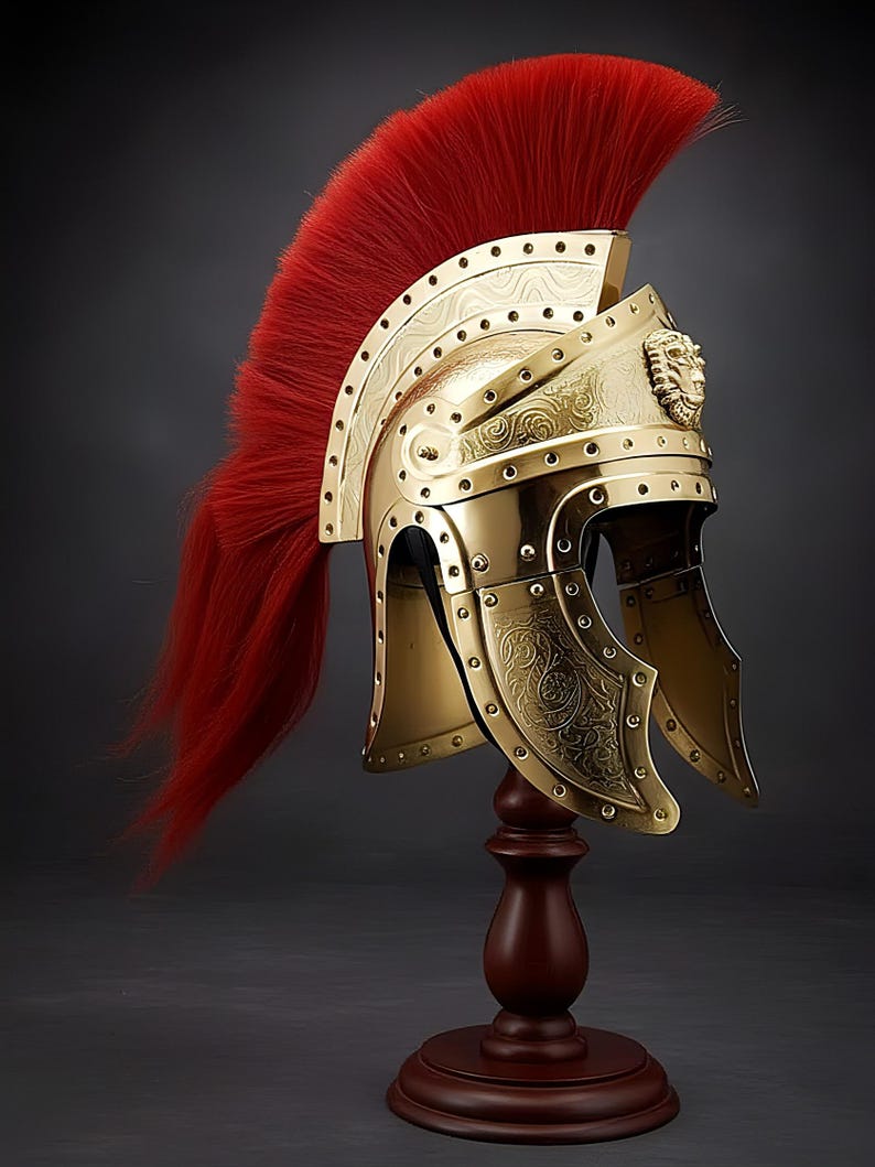 May include: A gold-colored Roman helmet with a red plume, displayed on a wooden stand. The helmet features intricate embossed designs and a lion's head emblem. The helmet is a decorative item.