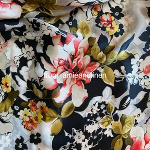 May include: Black and white floral fabric featuring large pink and white flowers and smaller yellow and white flowers. The fabric has a sheer, almost transparent appearance.