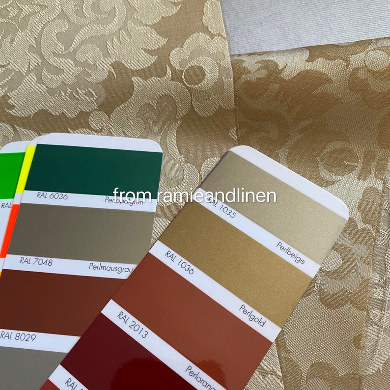 May include: A set of color swatches with RAL numbers and names. The swatches are arranged in a vertical column, with the top swatch being green, followed by gray, brown, and red. The names of the colors are written below each swatch, including "Perlgrun", "Perlmausgrau", "Perlorang", and "Perlbeige".