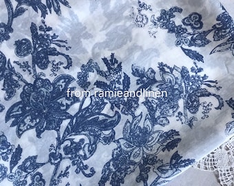 Puede incluir: Tela blanca con un patrón floral azul. La tela tiene una superficie ligeramente texturizada y un aspecto descolorido. El texto "from ramieandlinen" es visible en el centro inferior de la imagen.