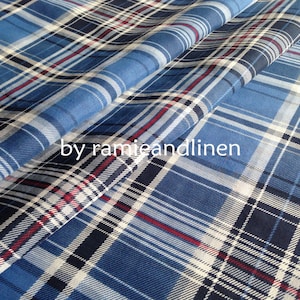 Könnte beinhalten: Blauer, weißer und roter karierter Stoff mit einer dezenten Textur. Der Stoff ist so gefaltet, dass Muster und Textur sichtbar sind.