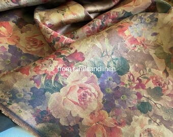 Puede incluir: Primer plano de una tela con estampado floral. La tela es de color marrón claro con un brillo dorado. Las flores son en tonos de rosa, rojo, morado y verde. La tela tiene un aspecto vintage.