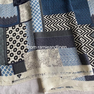 May include: A patchwork fabric with a variety of geometric and floral patterns in shades of blue, black, and white. The design includes zigzags, circles, and flower motifs. The text "from ramieandlinen" is visible.
